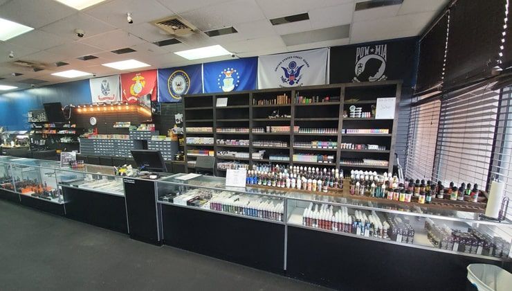 E-liquid shelves and glass counters behind the register at Cloud 9 Vapes on Airport Blvd in Mobile, AL