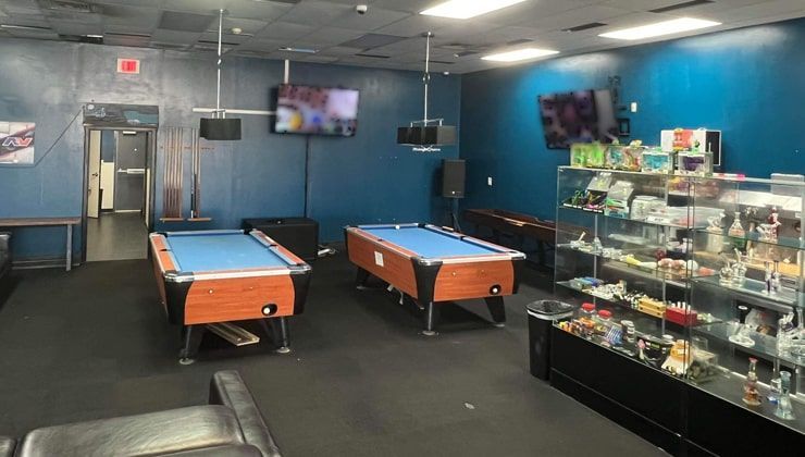 Vape lounge at Cloud 9 Vapes Airport Blvd, Mobile, AL Two pool tables, TVs and display cases in the lounge at Cloud 9 Vapes on Airport Blvd in Mobile, AL