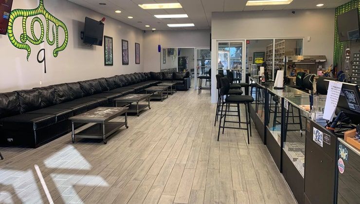 Black leather lounge seating along the wall at Cloud 9 Vapes in Daphne, AL