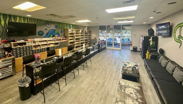 Sales floor at Cloud 9 Vapes in Daphne, AL, with lounge couches, bar seating and e-liquid shelves