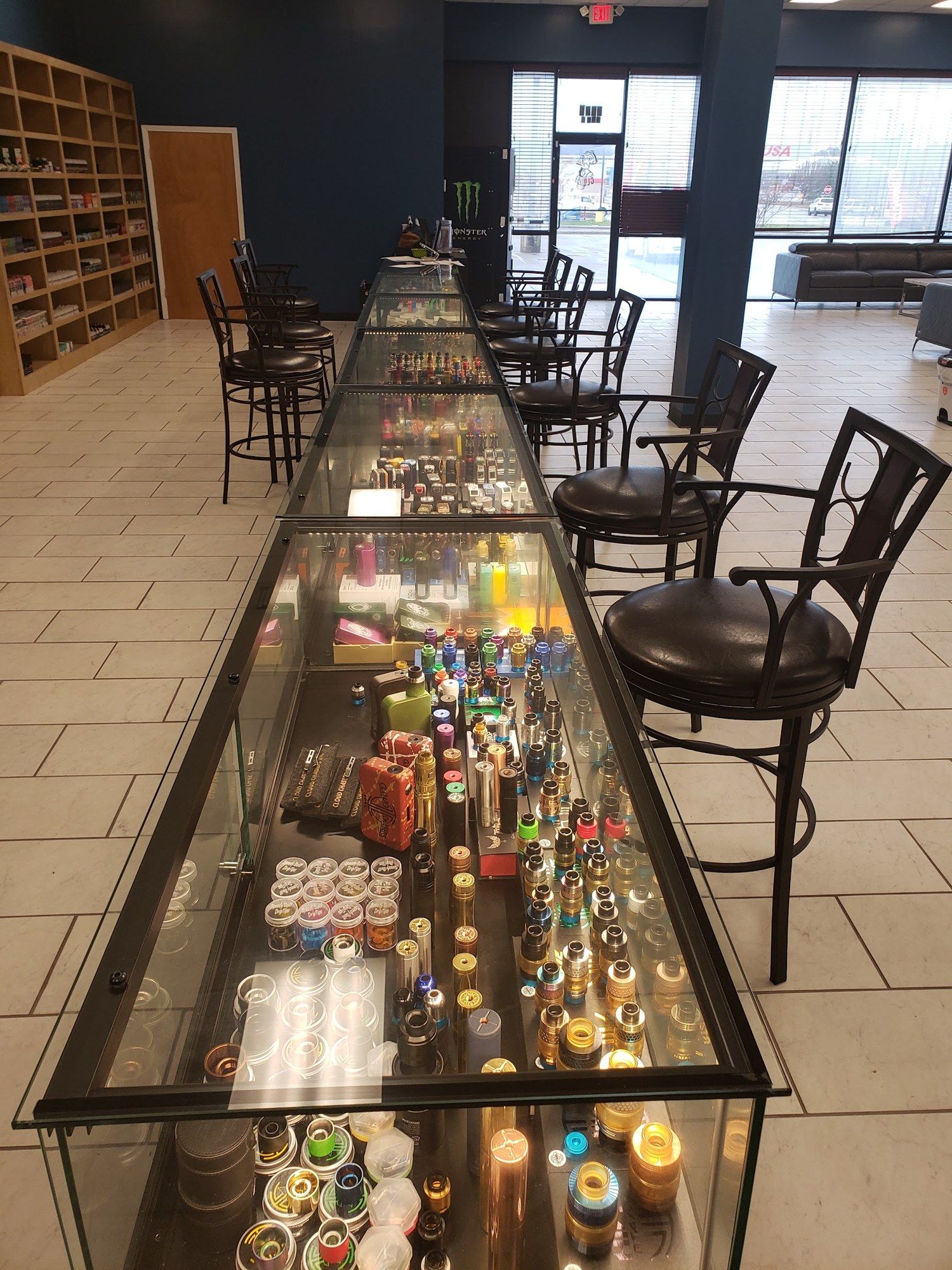 Sales floor with a long glass counter and bar stools at the Cloud 9 Vapes 24-hour vape shop in D'Iberville, MS