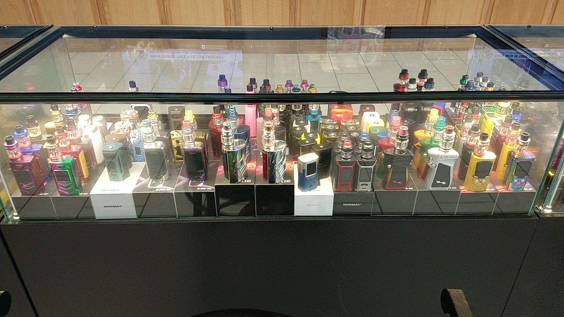 Lit display case of vape devices and tanks at Cloud 9 Vapes in D'Iberville, MS, near Biloxi