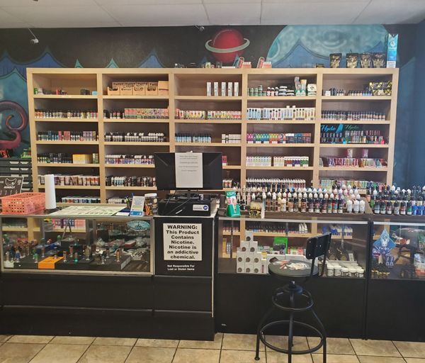 E-liquid counter at Cloud 9 Vapes Hillcrest E-liquid shelves and display counter under a planet mural at Cloud 9 Vapes Hillcrest in Mobile, AL