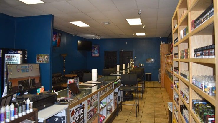 Sales floor at Cloud 9 Vapes Hillcrest, Mobile, AL Sales floor with blue walls and wood shelving at Cloud 9 Vapes on Hillcrest Rd in Mobile, AL