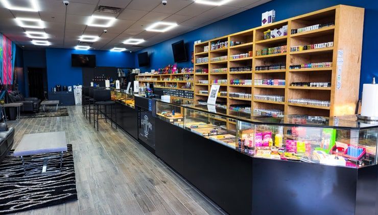 Sales floor at Cloud 9 Vapes Saraland, AL Long glass counter and wood e-liquid shelving at Cloud 9 Vapes in Saraland, AL