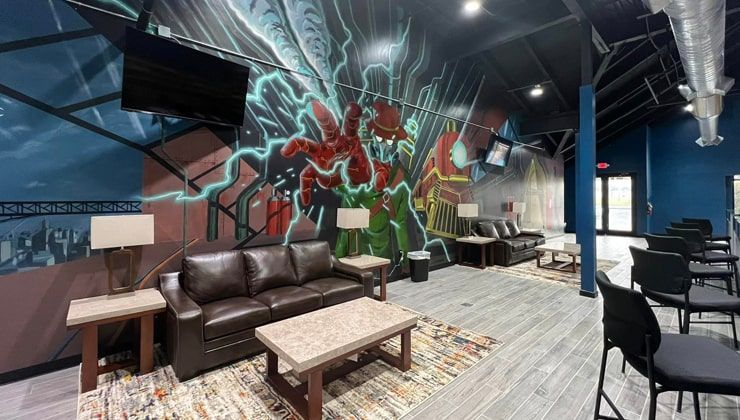 Lounge at Cloud 9 Vapes Tillman's Corner Leather couches and lamps under a floor-to-ceiling mural at Cloud 9 Vapes in Tillman's Corner, AL